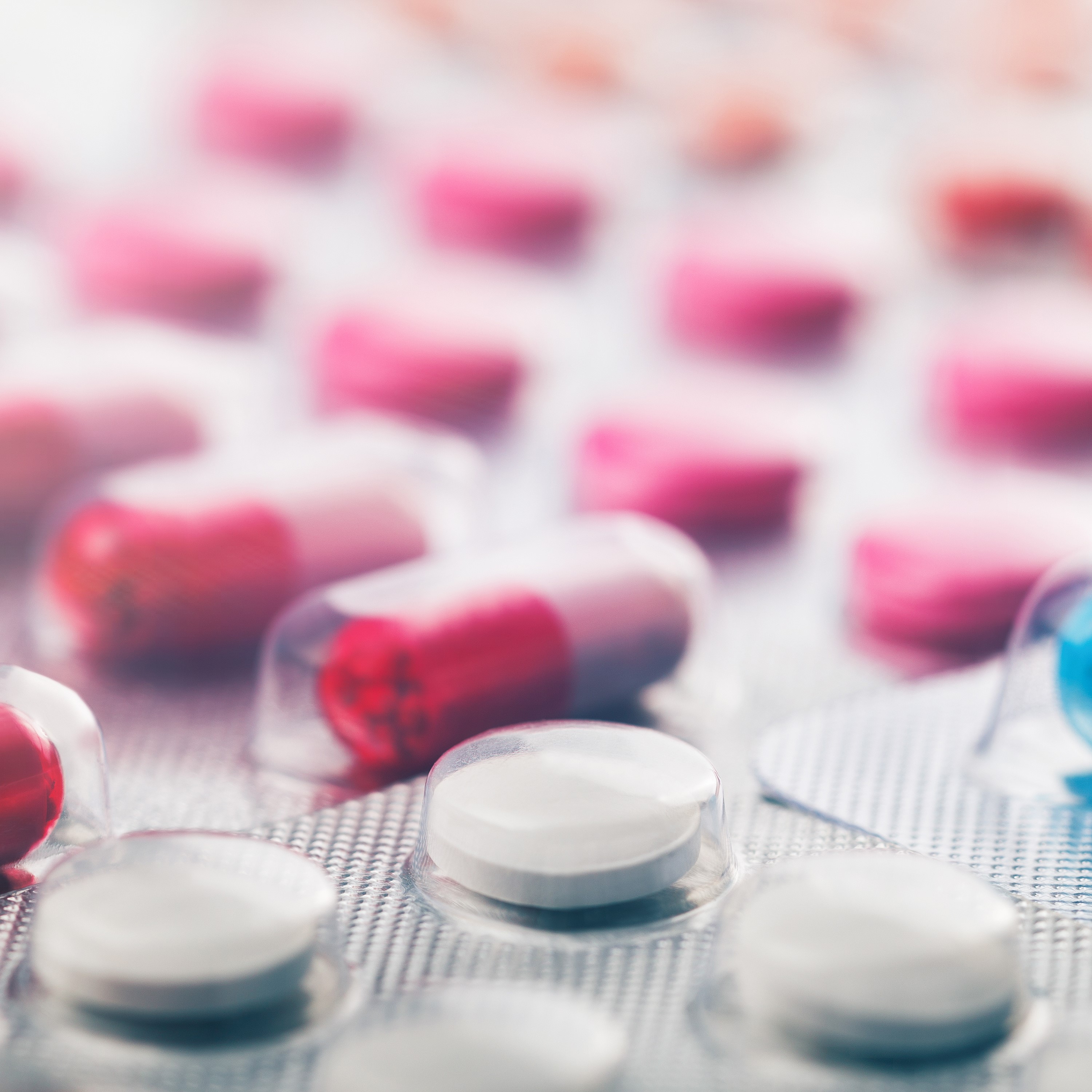 Heap of medical pills in white, blue and other colors. Pills in plastic package. Panoramic banner for design.