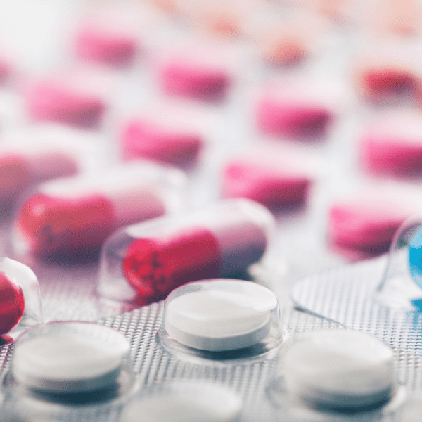 Heap of medical pills in white, blue and other colors. Pills in plastic package. Panoramic banner for design.