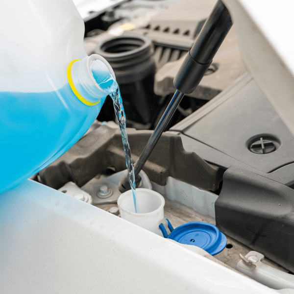 Pouring antifreeze. Filling a windshield washer tank with an antifreeze in winter cold weather.