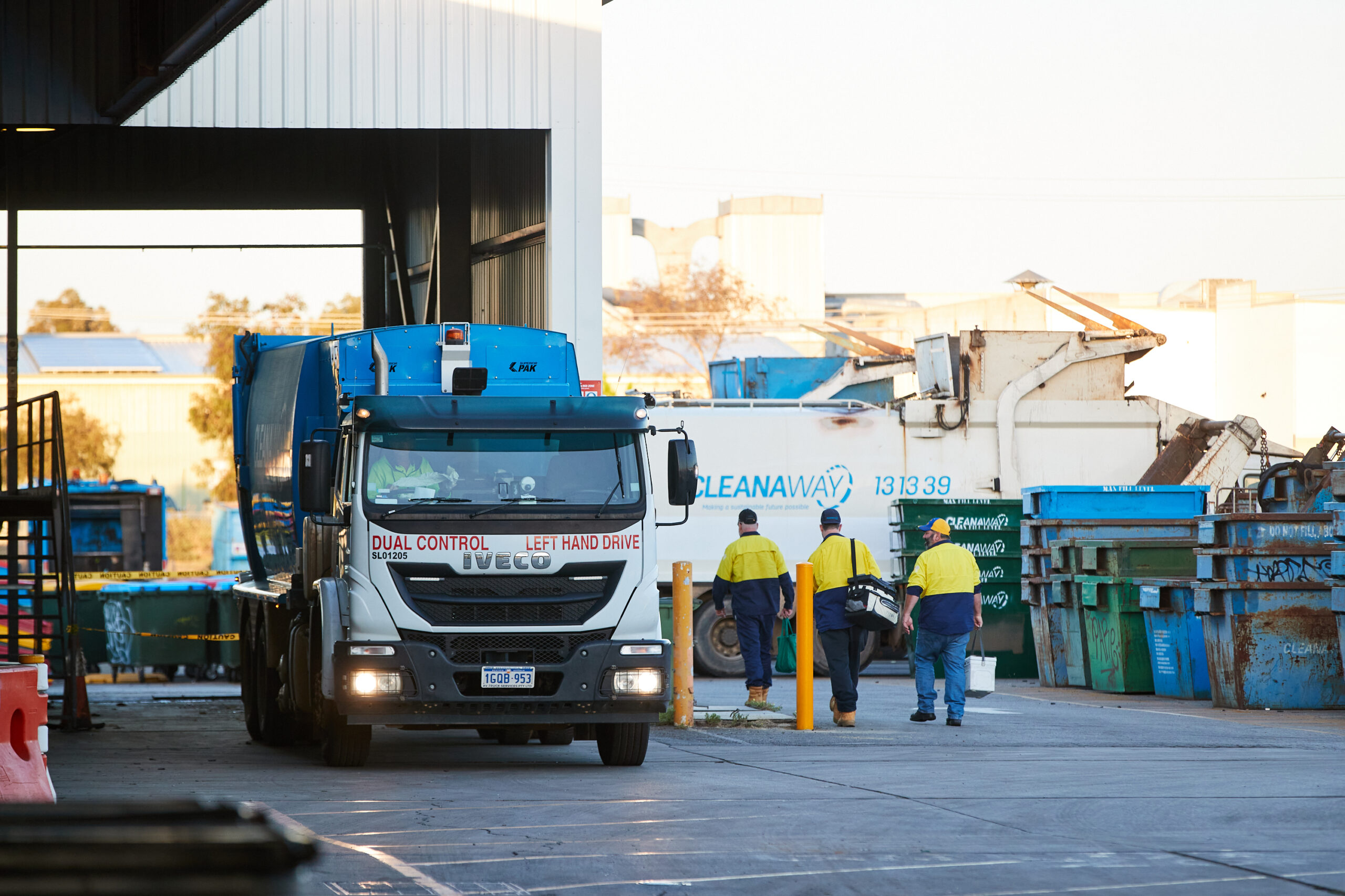 Cleanaway staff walking, truck with lights on
