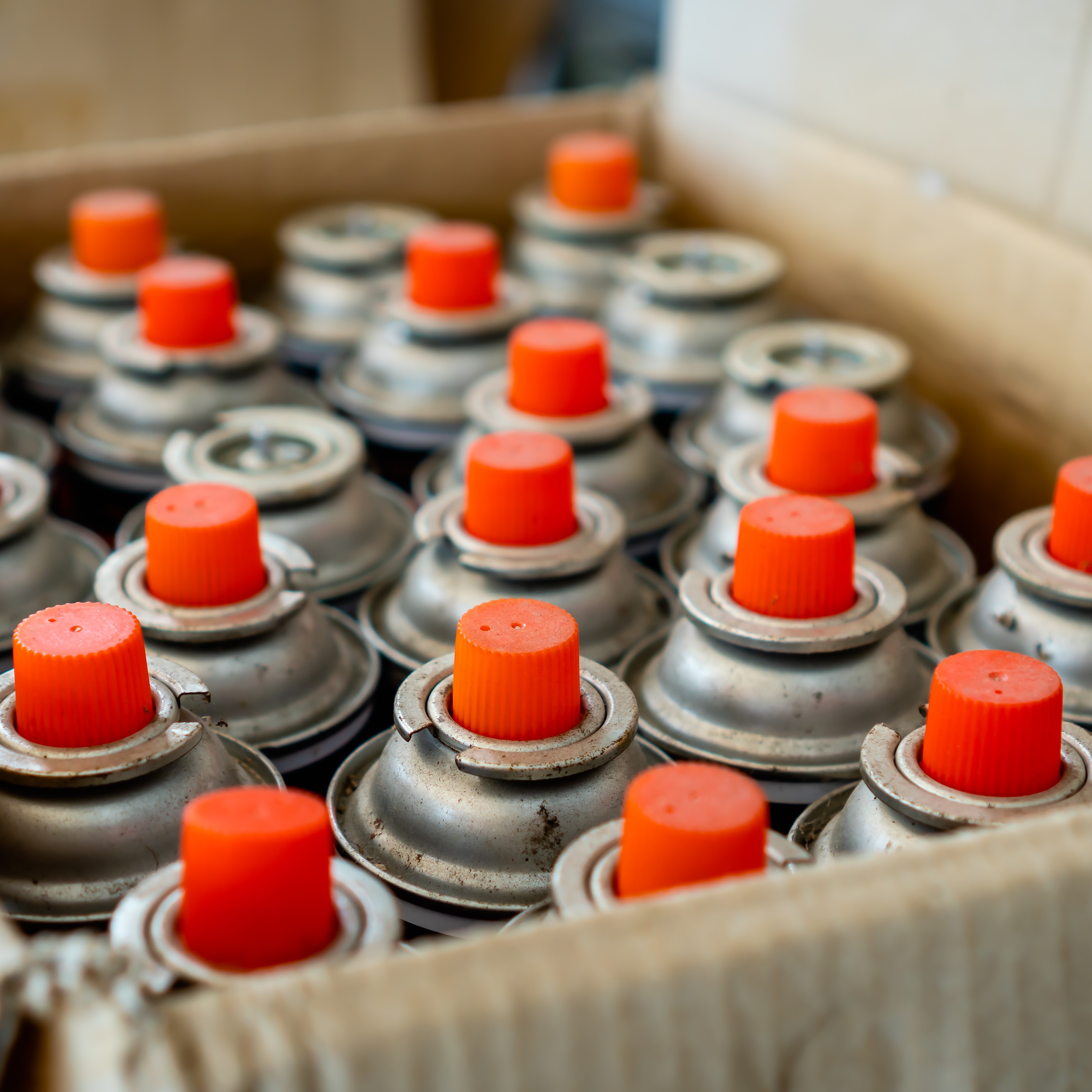 Old and used lubricant spray cans from automotive industry wait for recycling.