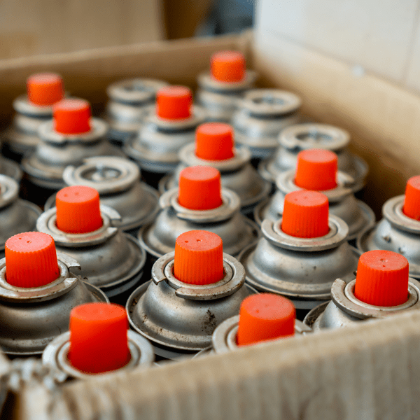 Old and used lubricant spray cans from automotive industry wait for recycling.