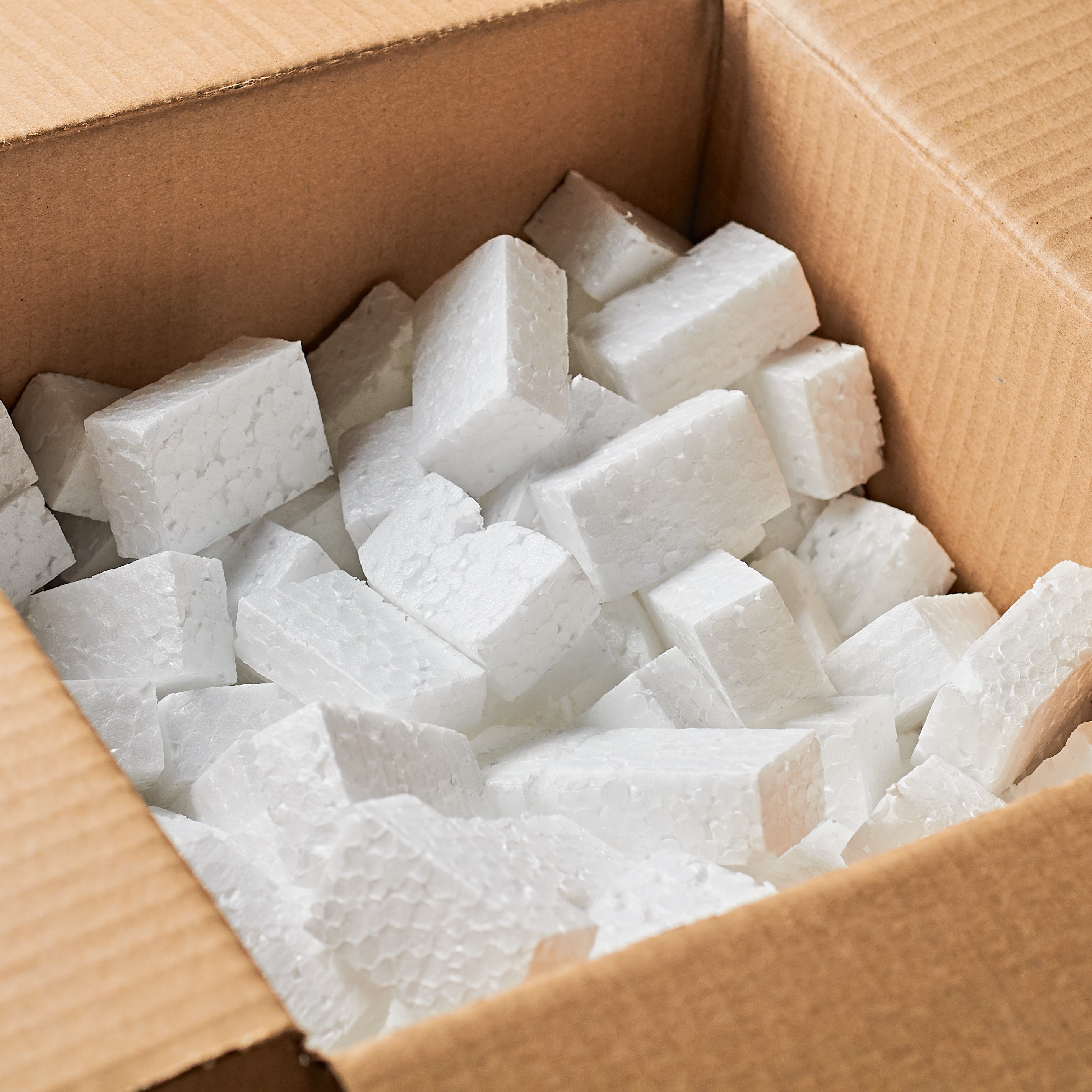 Open square cardboard box for parcels full of rectangular styrofoam blocks