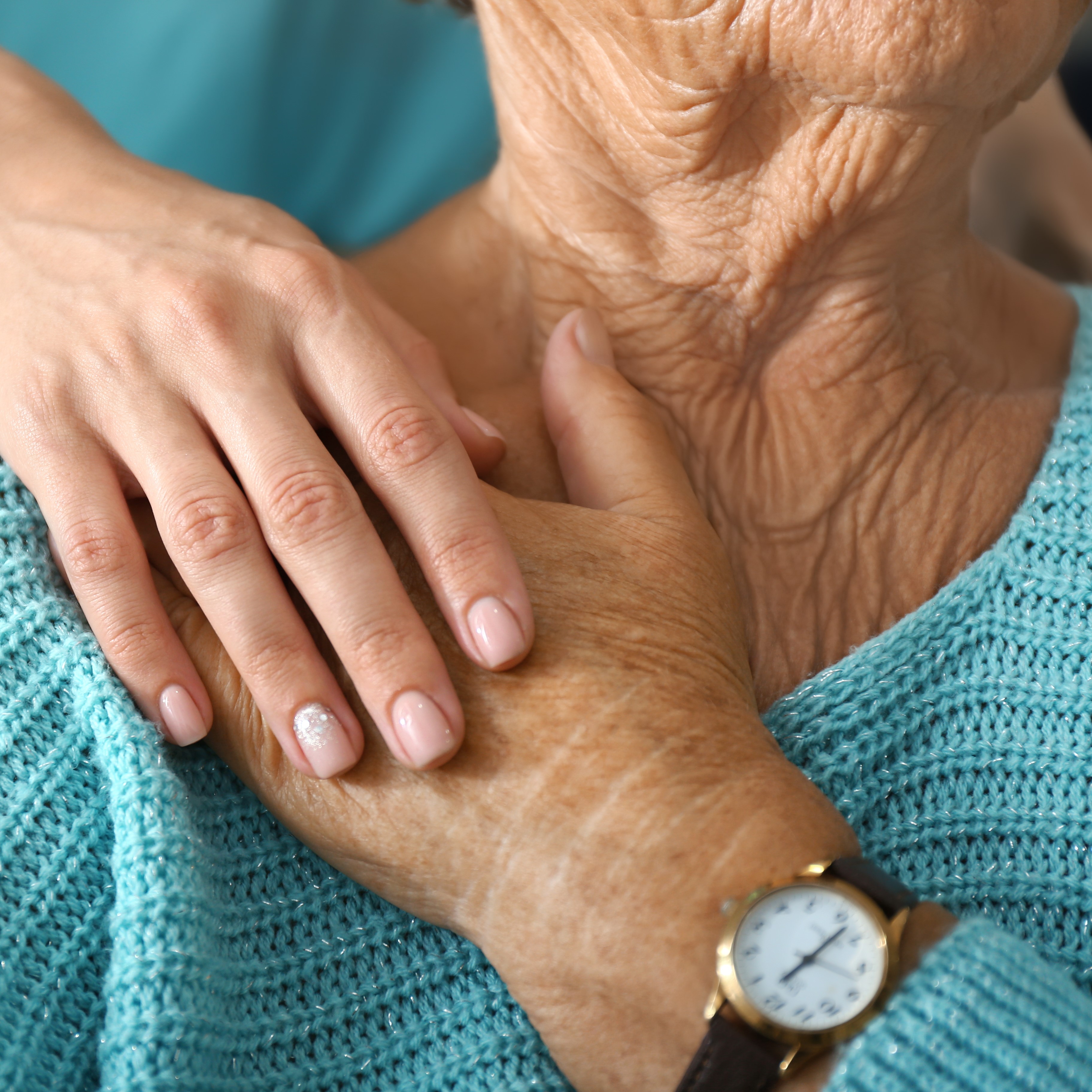 Doctor supporting elderly woman in clinic, closeup