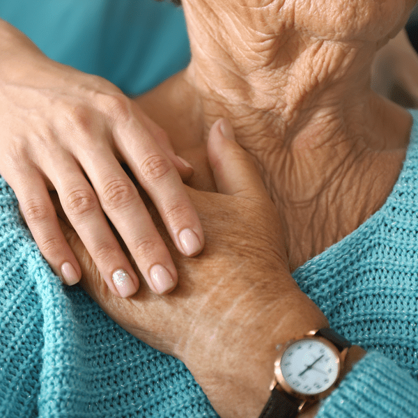 Doctor supporting elderly woman in clinic, closeup