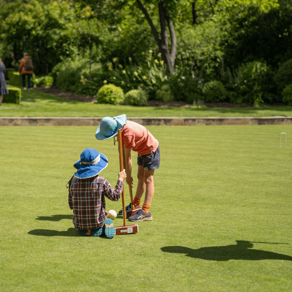 family playing croquet in a lawn playing field in australia