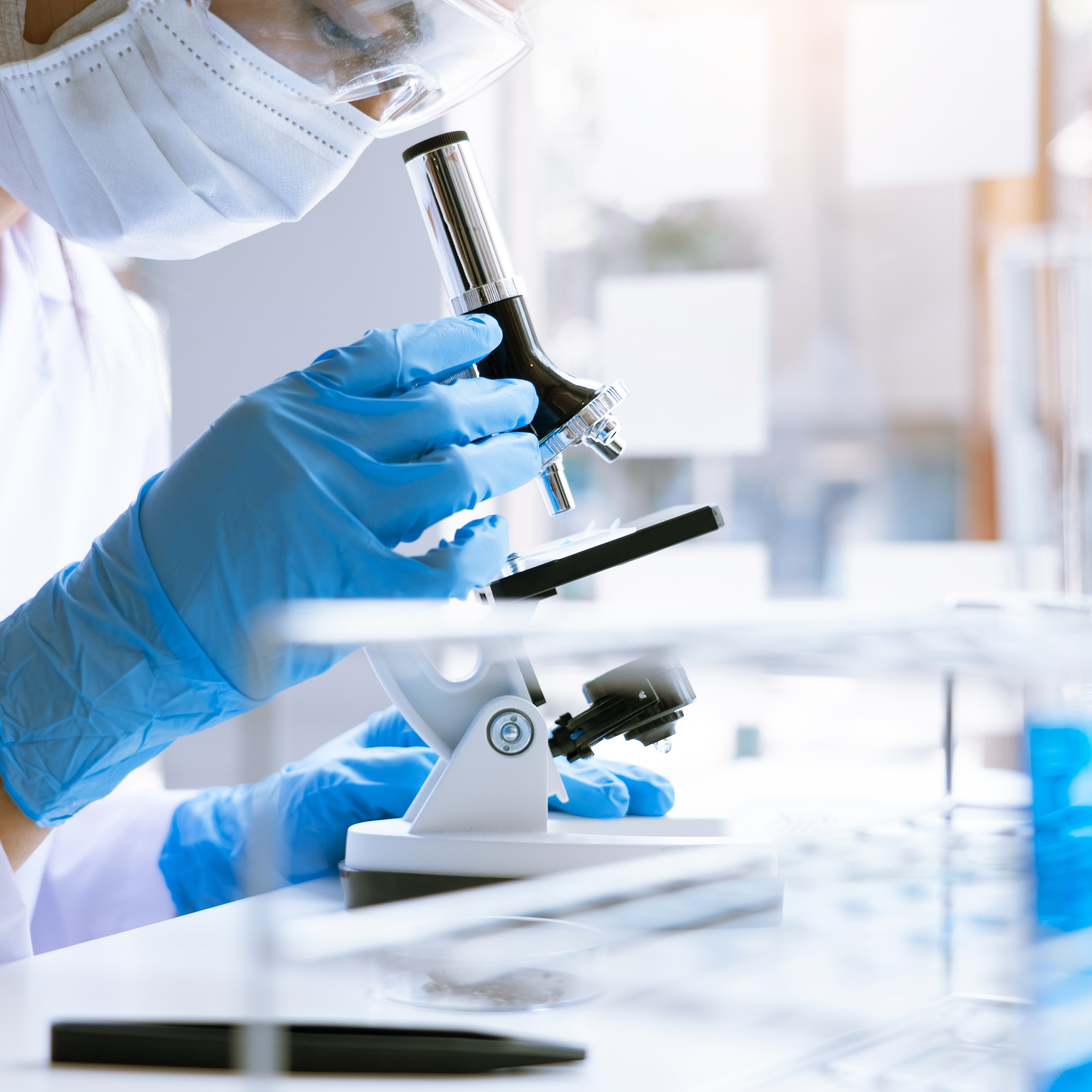 Medical Research asian Scientist Working With Microscope Doing Research Making Scientific Experiment, Works in a Bright Modern Laboratory.