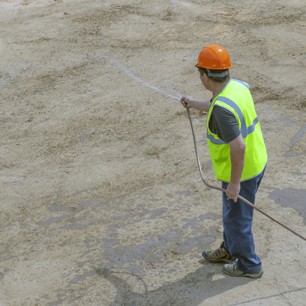 KHIMKI, RUSSIA - August 13, 2018: Worker at the construction site water from a hose
